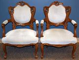 Lot# 179 HAND CARVED WOOD AND UPHOLSTERED FIRESIDE CHAIRS, C. 1930, PAIR, having carved crest, backrest, armrests, supports, seat frame and cabriolet legs. Newer light brown suede leather upholstery on back and arm rests and seat.
