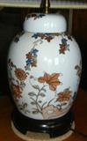 Lot# 206 PORCELAIN COVERED GINGER JAR CONVERTED TO LAMP, H 27", W 9", Flower and leaf design in blue, brown, peach & gold design. With white ground.