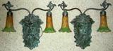 Lot# 205 FIGURAL & COLORED GLASS SCONCES, H 16", W 16", Verdi metal carved head of a male with an arm on each side and colored hanging shades. Colors of orange, brown and green. Flared at bottom.