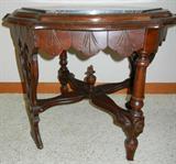 Lot# 241 MAHOGANY & MARBLE ANTIQUE AMERICAN LAMP TABLE, H 19", DIA 25", Black marble hexagonal insert with beige veining. Contoured edge of table with Eastlake style skirt; two spindle legs spaced opposite each other with two trestle style legs opposite each other all connected with cross stretchers with center finial;