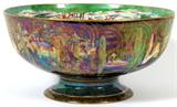 Lot# 1001 WEDGWOOD FAIRYLAND LUSTRE 'WOODLAND BRIDGE' PUNCH BOWL BY DAISY MAKEIG-JONES, C. 1920, DIA 9 1/2", A round bowl raised on a pedestal foot, the exterior adorned with poplar trees against a dark purple/black sky, the interior with "Woodland Elves V-Woodland Bridge" and "Mermaid" center; signed "MJ" in the pattern for Daisy Makeig-Jones (see additional photo), printed Portland vase mark at the underside along with pattern Z4968. Measures H.4 3/4", Dia.9 1/2".
