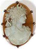 Lot# 1048 ITALIAN CARVED CAMEO BROOCH, 19TH C., H 2.5", DIANA THE HUNTRESS, 2.5" X 2".Exquisitely carved image of the goddess Diana with elaborate detail in hair, jewelry, facial details. Invisible setting structure with eight supporting spines set with seed pearls.
