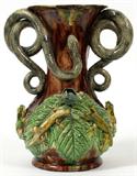 Lot# 1087 PORTUGUESE PALISSY WARE VASE IN THE MANNER MANUEL MAFRA, H 10 3/4", W 9", Urn-form vase flanked by snake handles, frogs and lizards on leaves about the base, glazed in brown, green and yellow. Not signed.
