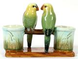 Lot# 1089 DELPHIN MASSIER, FRENCH MAJOLICA PARAKEETS JARDINIÈRE, VALLAURIS, LATE 19TH C., H 6", L 8", Unusual. Naturalistically modeled as two perched parakeets flanked by cylindrical planters, or bud vases, on a rectangular faux bois base, signed "Delphin Massier, Vallauris (A. M.) at the underside (see additional photo). Sold with the book "Massier L'Introduction de la Ceramique Artustuqye sur la Cote D'Azur". Two items total.