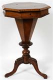 Lot# 1098 VICTORIAN BURL WALNUT & INLAID MARQUETRY SEWING TABLE, 19TH C., H 29", DIA 19", Octagonal hinged top opening to a fitted interior, raised on a baluster-form standard with tripartite base. Inlaid marquetry medallion at the top and banding along the edge.