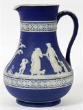 Lot# 1271 WEDGWOOD BLUE JASPERWARE PITCHER, LATE 19TH C., H 9", Medium blue pitcher decorated in white cameo relief with allegorical figures, including Cupid, impressed "Wedgwood, England" (see additional photo). Late 19th c.-circa 1900.