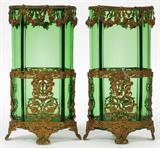 Lot# 1305 CONTINENTAL GREEN GLASS & PATINATED METAL VASES, C. 1900, PAIR, H 6 3/4", W 3 1/4", Each green glass vase is cartouche form and fitted within a conforming patinated metal frame featuring putti, floral swags, and scrolls. No apparent markings.