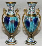 Lot# 1364 FRENCH CHAMPLEVÉ & FAIENCE VASES, 19TH C., PAIR, H 7 1/2", Each of classic urn shape with a ribbed faience body flanked by serpent-form handles, champleve neck and circular base decorated with a floral pattern in various pastel shades against a sky blue ground.