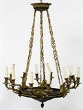 Lot# 2215 EMPIRE STYLE GILT AND PATINATED BRONZE 12 LIGHT DISC FORM CHANDELIER, H 30", DIA 27", Ca. early 20th c.; crown form ceiling cap; pierced scroll and wing motifs; electrified; downturned pineapple finial.