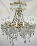 Lot# 2216 CRYSTAL TWELVE-LIGHT CHANDELIER, H 30", DIA 29", Gilt metal frame hung with crystal swags and prisms.