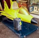 Lot #1, Vintage Electric Coin Operated Child Ride Airplane
Every child who passes a coin operated ride on toy wants to be allowed to ride! Now you can own your own electrical / mechanical ride-on airplane by having the winning bid on this lot. This is the type of kid's ride that was seen next to the gumball machines outside of grocery / convenience stores. The yellow painted metal airplane / rocket ship / jet sits on a large blue base which houses the mechanics. There is a male 3-prong, A/C power plug attached. Shows significant surface wear from use but still in great condition and appears to work when plugged in, the coin drop, made by "Coin Mechanisms Inc," appears to have been deactivated! It opens and closes on a hinged door. Coin return on the side. There is a push button start that seems "stuck", and thereby may or may not work. Is untested. The entire piece sits on a pair of front casters, and rear stabilizers. When tilted forward (For transport) a pair of smaller wheeled caste