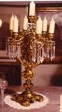 69/  Candelabra.  A 19th century French gilt bronze table candelabra in the style of Louis XV, six scrolling arms, supported by caryatids extending to the six candle sockets and connected by ormolu garlands.  A triple turn post with central candle holder.  The bobèche with faceted crystal drops.
24 3/4" high.  $2950.00
