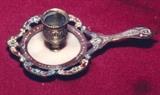 15/215  Candleholder.  A 19th century French champlevé candle holder of shaped and pierced outline, with handle.  The candle socket set in white onyx.
7 1/2" long x 4 1/2" high.  $195.00
