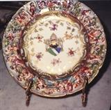 184/38  Plates.  A collection of three 19th century Italian Capodimonte plates of shaped outline.  The rim with figures in low relief with a Cavetto enameled in colored scrolls.  Each well shows a different papal coat of arms amidst leaves and blossoms.
8 1/2" diameter
Collection of three:  $375.00