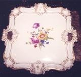 250/309  Tray.  A 19th century porcelain Meissen style tray with cross swords mark in underglaze blue on the back.  Hand painted with pierced handles within shaped outline, highlighted in gold.  Shells in the corner, small floral bouquet on cavetto and hand painted floral bouquet on well.
16 1/4" square.  $875.00.