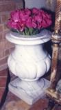 104/  Urns.  A pair of early 20th century marble urns, possibly Italian.  Carved of striated white marble, with a molded mouth, the neck swells to a fluted bulbous body.  Stemmed and on a circular foot and raised on a square base.
24" diameter, including the base.
The pair:  $950.00
