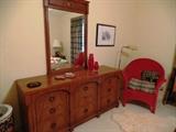 Solid Early American chest with mirror and colorful Wicker chair
