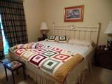 Metal Queen size bed and colorful quilts and blankets