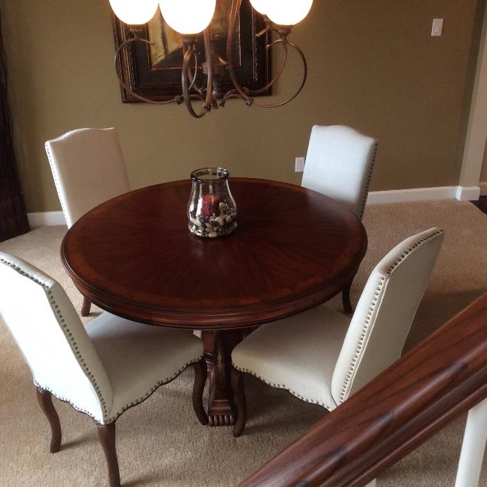 Elegant round dining table with claw feet and inlay design. This table can be purchased with or separately from these 4 white studded parsons chairs by Pier One!