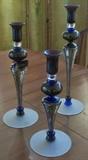 A very unique, beautiful glass set of candlestick holders.  Hand blown and signed by Ioan Nemtoi. Colors are magnificent! Cobalt blue, black, with a little grey, green & orange. Heights: 15½ " h, 13" h, 11¼ " h $140/each or $400 for set of 3 