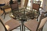 Glass on iron table and four rolling chairs.