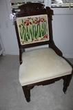 Antique chair with needlepoint back cushion.