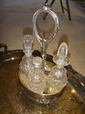 crystal glass cruet set with one vinegar missing on silver plate tray.