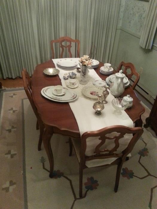 Bassett cherry wood dining room table and four chairs with upholstered seats.