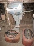 Vintage Evinrude outboard motor with original gas cans