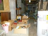Basement contains shelves, office supplies, shop table on wheels, Selectric typewriter, old typewriter stand, etc.