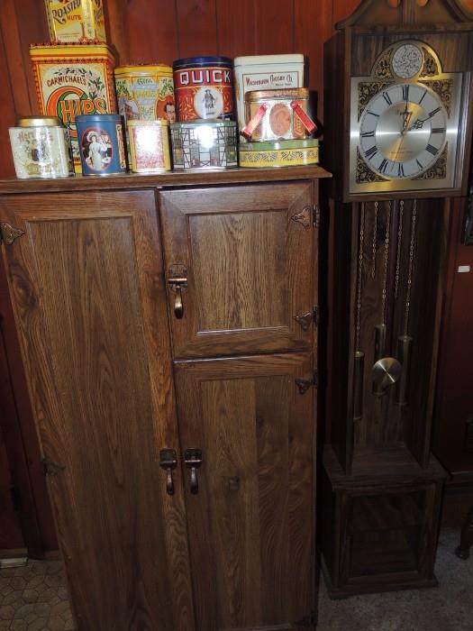 Ice box style pantry cabinet, Powell battery op clock, collection of tins, more in cabinet