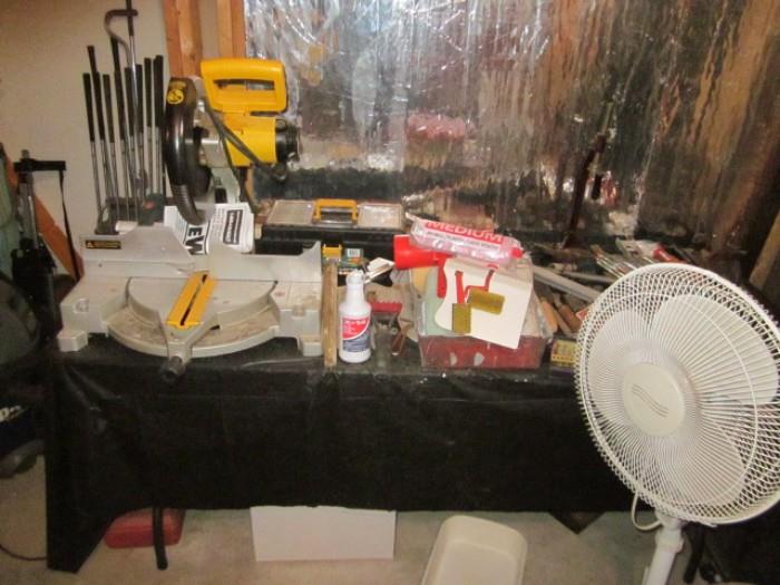DeWalt cut off saw plus other tools & items on table.