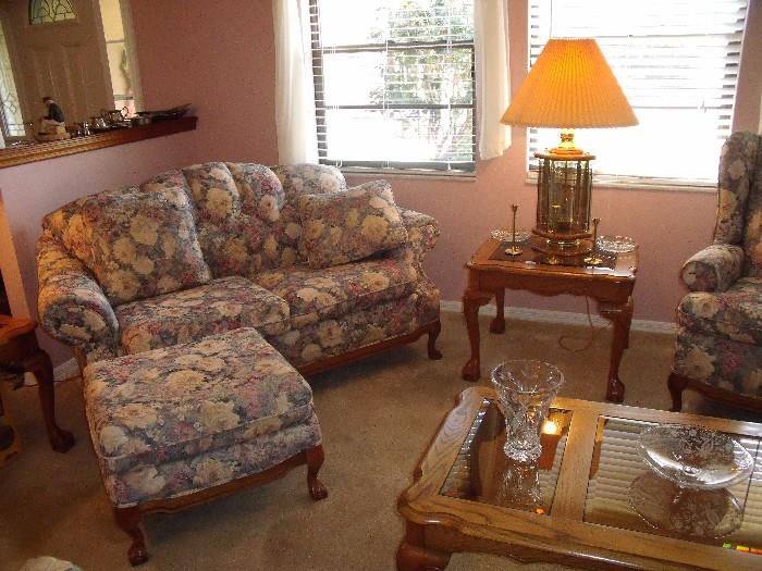 Upholstered and tufted love seat.  Ottoman, which goes with the chair, is shown in front of love seat.