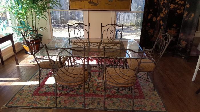 glass top and iron table and iron chairs on top of a vintage hook rug!