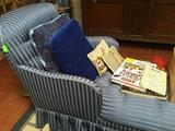 Blue on blue striped chaise lounge, decorative pillows and books