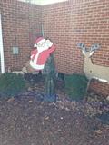 Santa cut out with Rudolph, the little dog is lifting his leg but its behind the bush!