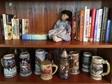 Books, porcelain face doll and collectors beer mugs. 