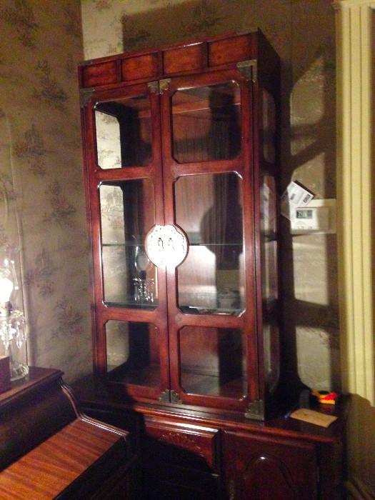 China cabinet has 3 glass shelves and recessed lighting at top.