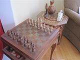 A brass topped game table with sets of chess, backgammon and checkers.