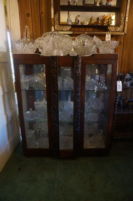 A very unique and beautiful carved wood art deco china cabinet loaded with cut glass