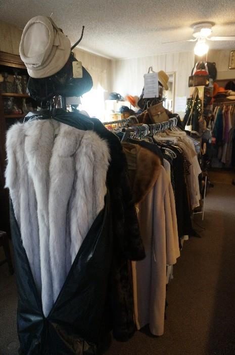 Fur coats and racks of clothing in addition to the clothes in the closets