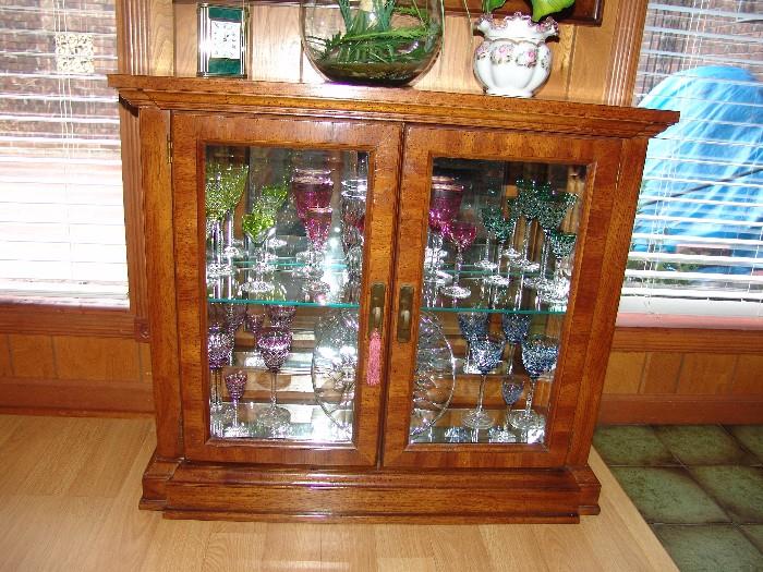 Curio cabinet with numerous pieces of Val St. Lambert colored cut to clear stemware