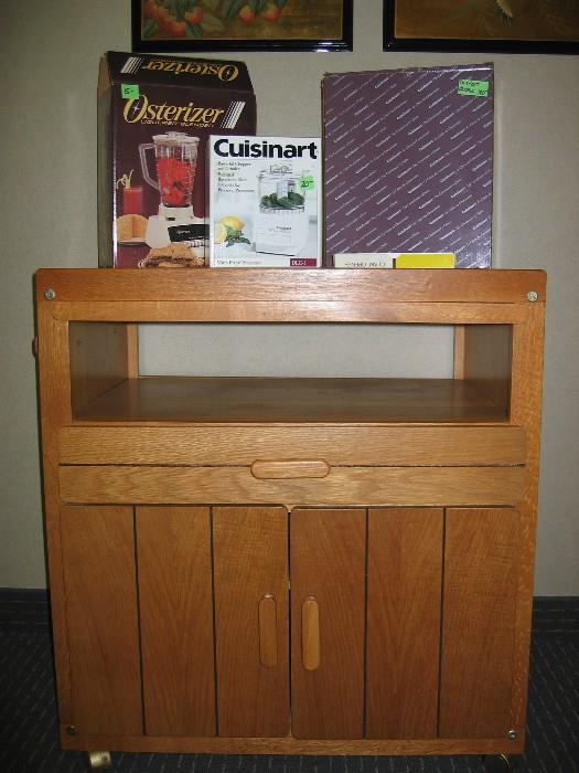 Kitchen rolling cart, Quisinart Classic food processor still in box, small quisinart never used in box and Osterizer blender.  All items put on floor this week.
