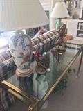 Plaid sofa; brass & glass sofa table; lamps; bird figurines.