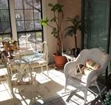 Wicker Rocker and Large Artificial Plants