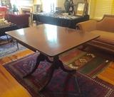 Mahogany Duncan Phyfe drop leaf table with brass feet.  Rugs