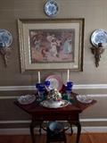 Nicely framed and mated print, flanked by pair of sconces and blue & white china. 