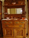 Two-piece oak sideboard with ornate applied molding and beveled mirror.