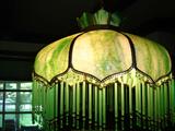 One of two green, curved-slag-glass paneled lamps with beaded fringe.  (not available for removal until end of sale)