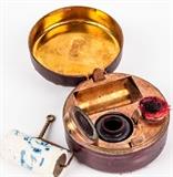 Lot #176, Antique Pocket / Travel Inkwell & Blotter
An antique pocket / travel inkwell set with brush, roller blotter, and original glass insert. Items are contained in a leather covered tin. Top of kit is stamped "Ink" and just above the hinge the leather is incised "Made in USA". There are no other manufacturer markings nor dates on the item. Used but good condition. Measures about 1.75" tall x 2.75" diameter. Tag Words: Intdes, desktop, school, desk, home office